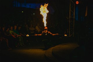 Feuerartist spuckt Feuer während des Konzerts.