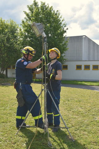 Prüfer Luis Storch mit Prüfling beim Aufbau des Lichtstatives.