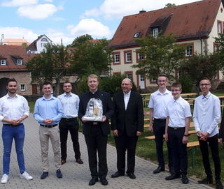 Eine Abordnung von Jugendleitern und Messdienern aus der Pfarrei St. Elisabeth mit dem neugeweihten Diakon Philipp Schöppner (4. Von links) und Dechant Andreas Weber beim Gratulieren mit Abstand  im Garten des Domes