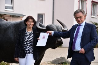 Staatssekretär Michael Bußer übergibt den Festsetzungsbescheid für Erlensee an Erste Stadträtin Birgit Behr.