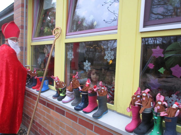 Große Augen schauen von innen auf die gefüllten Stiefel in der KiTa Sandweg. Hier spazierte der Nikolaus im Garten herum und brache Geschenk mit - Foto: Stadtverwaltung Erlensee