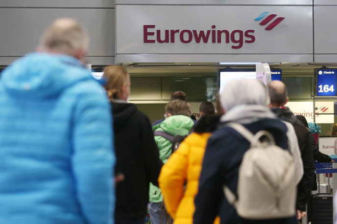 assagiere stehen am Flughafen Düsseldorf in einer Schlange, um für einen Eurowings-Flug nach Palma de Mallorca einzuchecken.  - Foto: picture alliance/dpa | David Young