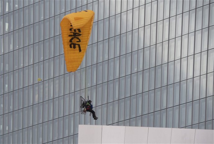 Mit einem Gleitschirm landet ein Greenpeace-Aktivist auf dem Dach der Europäischen Zentralbank - picture alliance/dpa | Boris Roessler