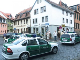 Polizisten und Zeugen vor dem Eckhaus in der Fuldaer Florengasse, in dem Dorit Botts, die Inhaberin eines Military-Shops, am 17. August 2001 - kurz vor ihrem 54. Geburtstag - getötet wird. 