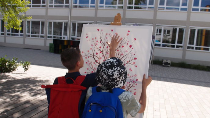 Bei einem Mitmachkunstwerk beim zweiten Hanauer Fest der Religionen entsteht auf einer Leinwand ein Mandelbaum als Symbol der Hoffnung.