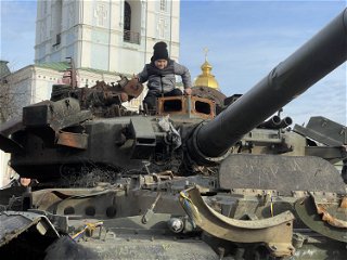 Ein Kind klettert auf einem zerstörten russischen Panzer
