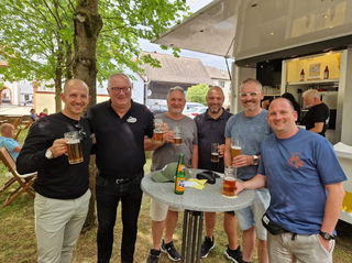 Bürgermeister Dominik Brasch (l.) und Michael Graf, Geschäftsführer der KINZZ Brauerei (2.v.l.), begrüßen die ersten Gäste im neuen Pop-UP-Biergarten im historischen Schleifrashof in der Altstadt von Salmünster. 