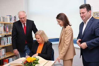 Nancy Faeser trägt sich im Beisein von Bürgermeisterin Monika Böttcher, Erstem Stadtrat Karl-Heinz Kaiser und Hubertus Heil in das Goldene Buch der Stadt Maintal ein.