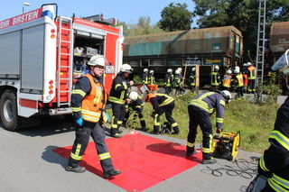 Dramatik im Szenario an der Bahn-Entladestelle: Mehrere Personen geraten unter einen Güterwaggon. Die Feuerwehren und Rettungsdienste bereiten die Rettung vor.