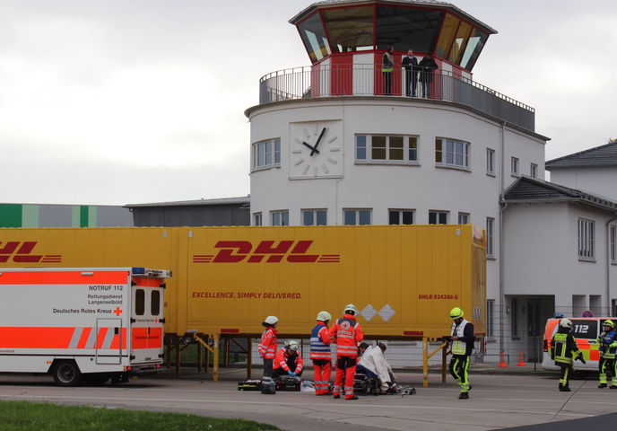 Blick auf das Einsatzgeschehen mit Fliegerhorst-Tower im Hintergrund. Hier werden die Verletzten versorgt.